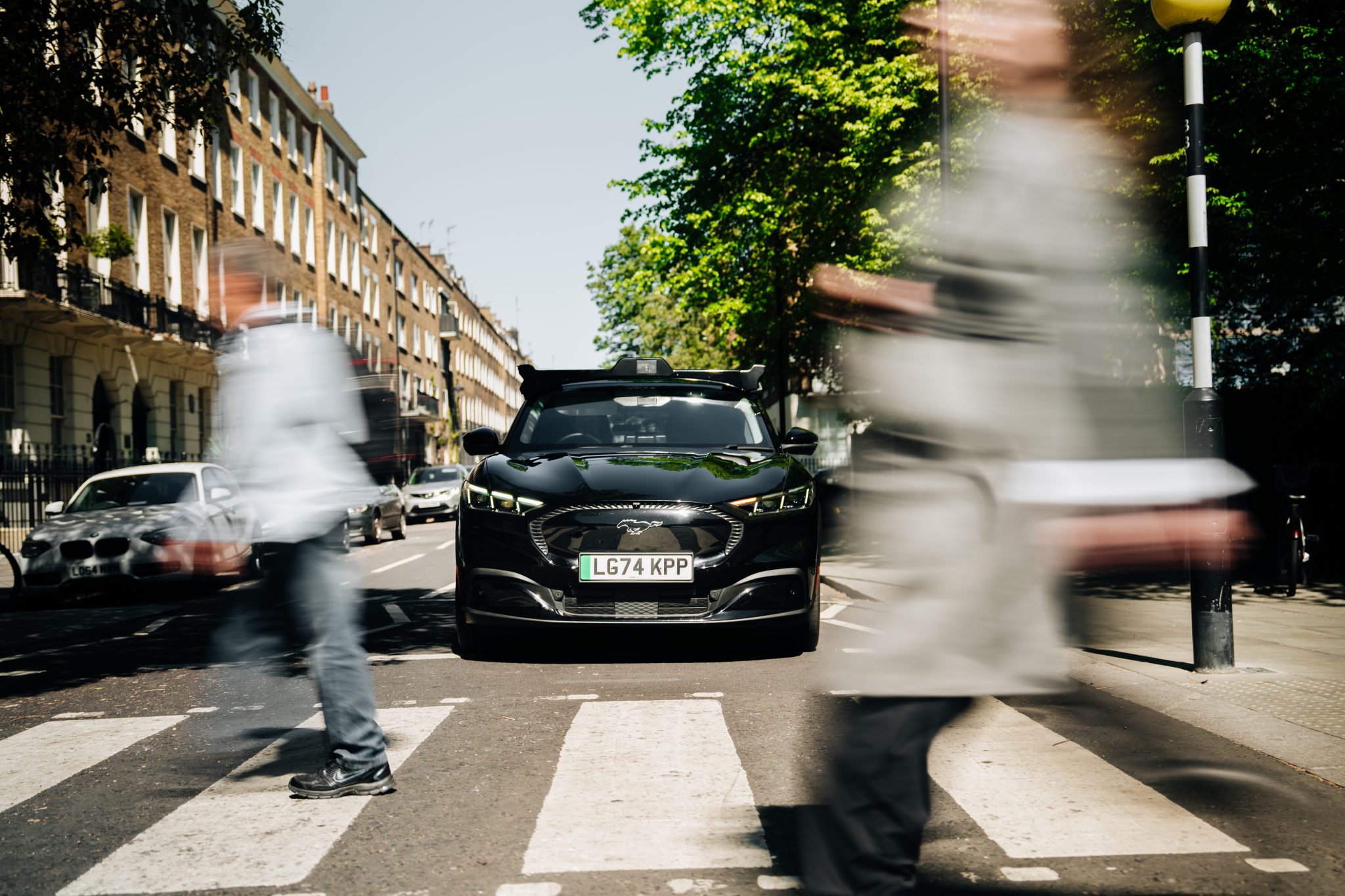 black car stopped at zebra crossing